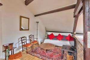 Un dormitorio con una cama con almohadas rojas y una mesa. en Rustic Bohemian Duplex in Meudon, en Meudon 6 fotos más