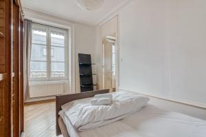 Una habitación blanca con una cama y una ventana en GuestReady - Superbe T3 en hyper-centre - belles vues, en Fourvière