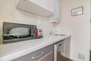 un microondas sentado en una encimera en una cocina en GuestReady - Superbe T3 en hyper-centre - belles vues, en Fourvière