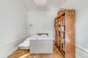 1 dormitorio con 1 cama y estantería con libros en GuestReady - Superbe T3 en hyper-centre - belles vues, en Fourvière