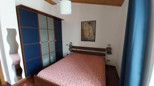 a small bedroom with a bed and a blue door at vignale holiday house in La Spezia