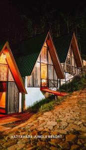 a house with a green roof on a dirt road at Vattavada Jungle Resort in Munnar