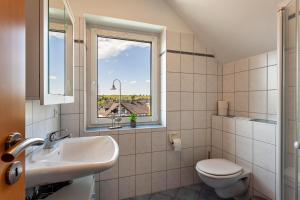 a bathroom with a sink and a toilet and a window at Ferienhaus Am Brande in Schmallenberg