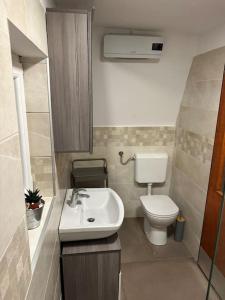 a small bathroom with a toilet and a sink at Lovely wooden cabin in Log pod Mangartom