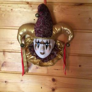 a mask with a hat on a wooden wall at Roulotte Fenouillet in Hyères