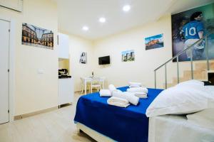 una camera da letto con un letto blu con asciugamani sopra di Basso ai Quartieri experience a Napoli