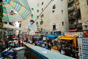 una folla di persone che camminano in un mercato con un ombrello di Basso ai Quartieri experience a Napoli