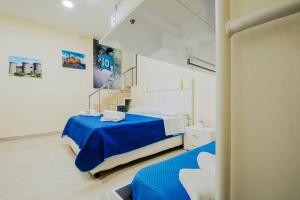 una camera da letto con due letti con lenzuola blu di Basso ai Quartieri experience a Napoli