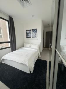 a white bedroom with a large bed and a window at 48 residence in Kuwait