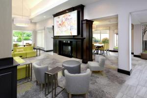 uma sala de estar com televisão e lareira em Hilton Garden Inn Greensboro em Greensboro