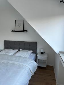 a bedroom with a white bed and a white nightstand at Thê Rath Residence in Düsseldorf