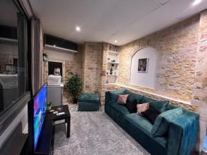 uma sala de estar com um sofá verde e uma TV em Entire Modern studioin zamalek em Cairo