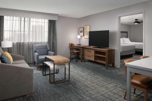 Homewood Suites by Hilton San Antonio Riverwalk/Downtown في سان انطونيو: غرفة فندقية بسرير ومكتب مع تلفزيون