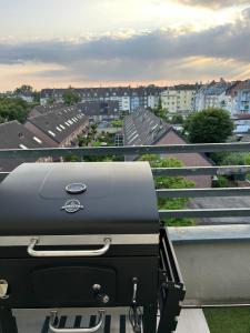 a grill on a balcony with a view of a city at Thê Rath Residence in Düsseldorf