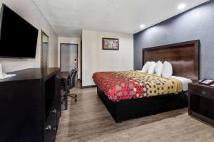 a hotel room with a bed and a flat screen tv at Econo Lodge Akron Copley Northwest in Montrose