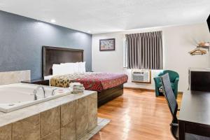 a hotel room with a bed and a bath tub at Econo Lodge Akron Copley Northwest in Montrose
