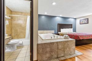 a hotel room with a bathroom with a bed and a tub at Econo Lodge Akron Copley Northwest in Montrose +35 photos