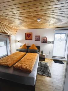 - une chambre avec un grand lit et un plafond en bois dans l'établissement Ferienwohnung Classen Eifel, à Schleiden