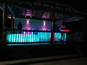 a woman standing next to a swimming pool at night at Falcon Lodge ET in Bela-Bela +32 photos