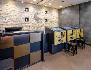 an office lobby with a counter and chairs and a brick wall at Comfort Hotel Nagoya Shinkansenguchi in Nagoya