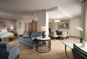レドンドビーチにあるSonesta Redondo Beach and Marinaのベッドとリビングルームが備わるホテルルームです。