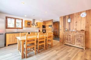 a kitchen with wooden cabinets and a table and chairs at Maison conviviale à Valloire + Jardin in Valloire