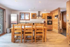 a kitchen with wooden cabinets and a table and chairs at Maison conviviale à Valloire + Jardin in Valloire