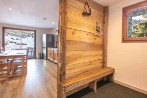 a kitchen and dining room with a wooden wall at Maison conviviale à Valloire + Jardin in Valloire +16 photos