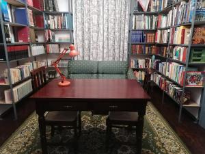 a library with a table and a couch and book shelves at Casa do Castelo in Fronteira