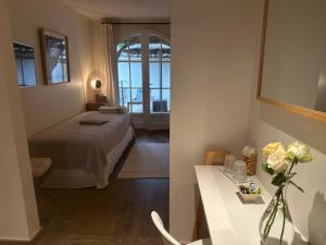 um quarto com uma cama e uma mesa com flores em Le Clos des Sept Palmiers em Cavalaire-sur-Mer