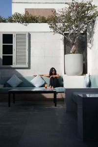 Kempinski Central Avenue Dubai في دبي: امرأة تجلس على أريكة في غرفة المعيشة