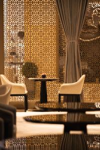 Kempinski Central Avenue Dubai في دبي: غرفة بها كرسيين وطاولة وعمود