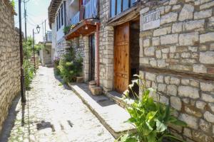 an alley in an old stone building with a wooden door at Guest House Vasili in Berat