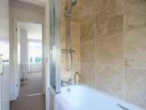a bathroom with a bath tub and a shower at Castaway, Port Isaac Bay Holidays in Port Isaac