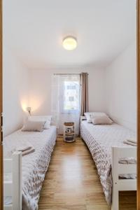 two beds sitting next to each other in a bedroom at Grego in Milna