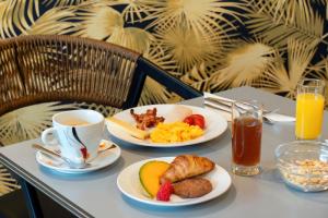 a table with two plates of food and a cup of coffee at Best Western Plus Hôtel Belfort Centre Gare in Belfort
