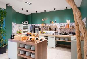 a kitchen with green walls and a counter with dishes at Best Western Plus Hôtel Belfort Centre Gare in Belfort