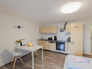a kitchen with a table and a white table and chairs at B2 - Urlaubsmagie - mit Terrasse& Grill direkt am Wanderweg in Sebnitz