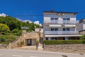 a white building with a stone wall next to a street at Hot Tub, Pool & Stunning View #Guest House Stella# in Dramalj