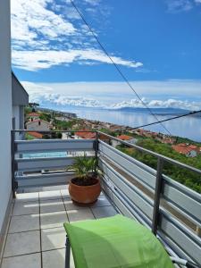 a balcony with a green chair and a view of the water at Hot Tub, Pool & Stunning View #Guest House Stella# in Dramalj
