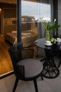 uma cadeira preta e uma mesa com um vaso de flores em Onyx Palace DeLux em Batumi