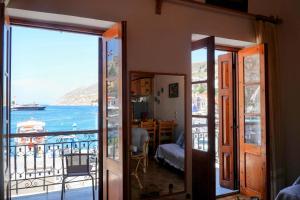 a room with a balcony with a view of the ocean at Amorosa House in Symi