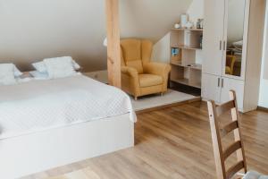 a bedroom with a bed and a chair at Pas Aldona in Palanga