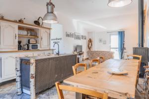 una cucina e una sala da pranzo con tavolo e sedie in legno di Gites La Boletiere a Saint-Étienne-du-Valdonnez