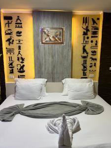 a bed in a room with writing on the wall at Comfort Sphinx Inn in Cairo