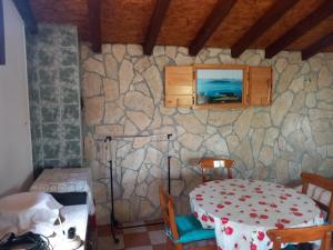 a dining room with a table and a stone wall at Magunja in Neviđane