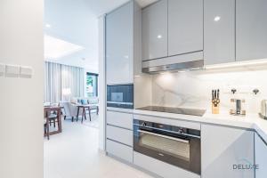 Η κουζίνα ή μικρή κουζίνα στο Seafront 4BR Apartment with Assistant Room in The Address Fujairah Residences Block B, Fujairah by Deluxe Holiday Homes