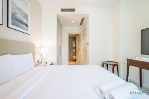 Ένα ή περισσότερα κρεβάτια σε δωμάτιο στο Seafront 4BR Apartment with Assistant Room in The Address Fujairah Residences Block B, Fujairah by Deluxe Holiday Homes