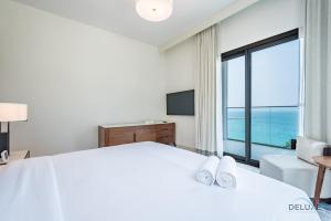 Ένα ή περισσότερα κρεβάτια σε δωμάτιο στο Seafront 4BR Apartment with Assistant Room in The Address Fujairah Residences Block B, Fujairah by Deluxe Holiday Homes
