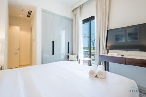 Ένα ή περισσότερα κρεβάτια σε δωμάτιο στο Seafront 4BR Apartment with Assistant Room in The Address Fujairah Residences Block B, Fujairah by Deluxe Holiday Homes
